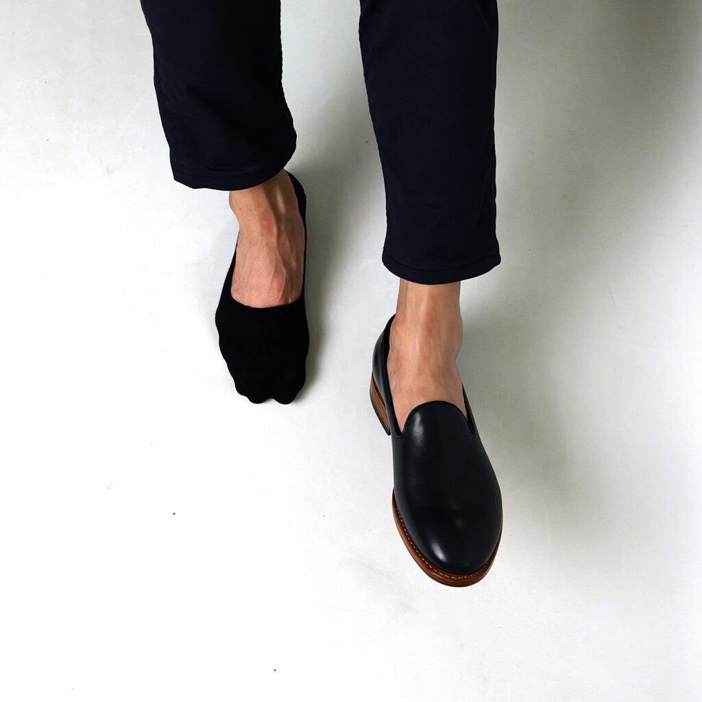 AGAM socks ECLIPSE LoaferFit on right foot with black shoe on left foot